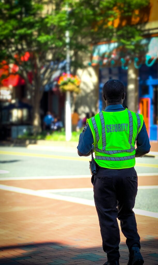Home 33 Guardia de seguridad de espaldas con chaleco reflectivo, representando la verificación de porteros y vigilantes en propiedad horizontal