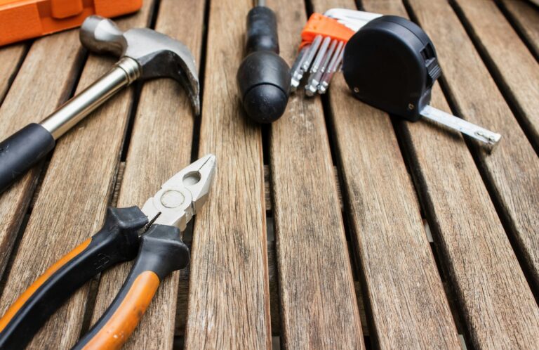 Herramientas de mantenimiento sobre superficie de madera, representando la verificación de personal de mantenimiento y toderos
